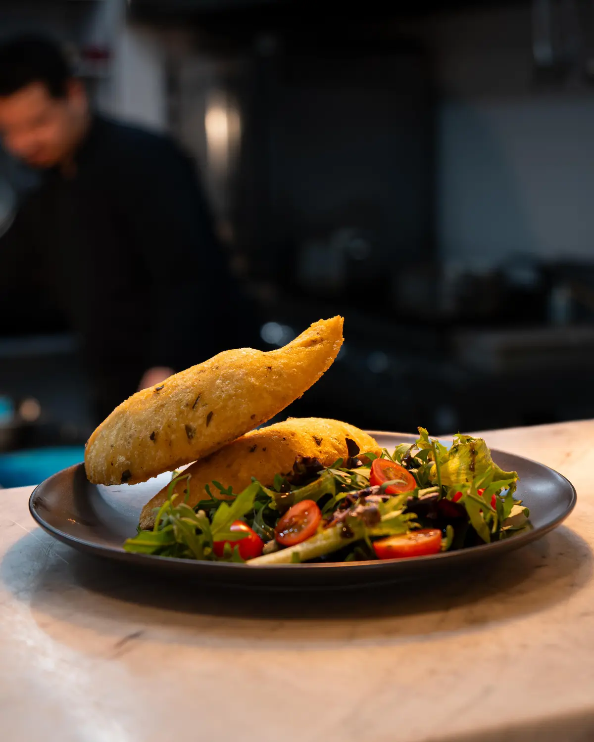 Salada de folhas e tomate-cereja com uma empanada.